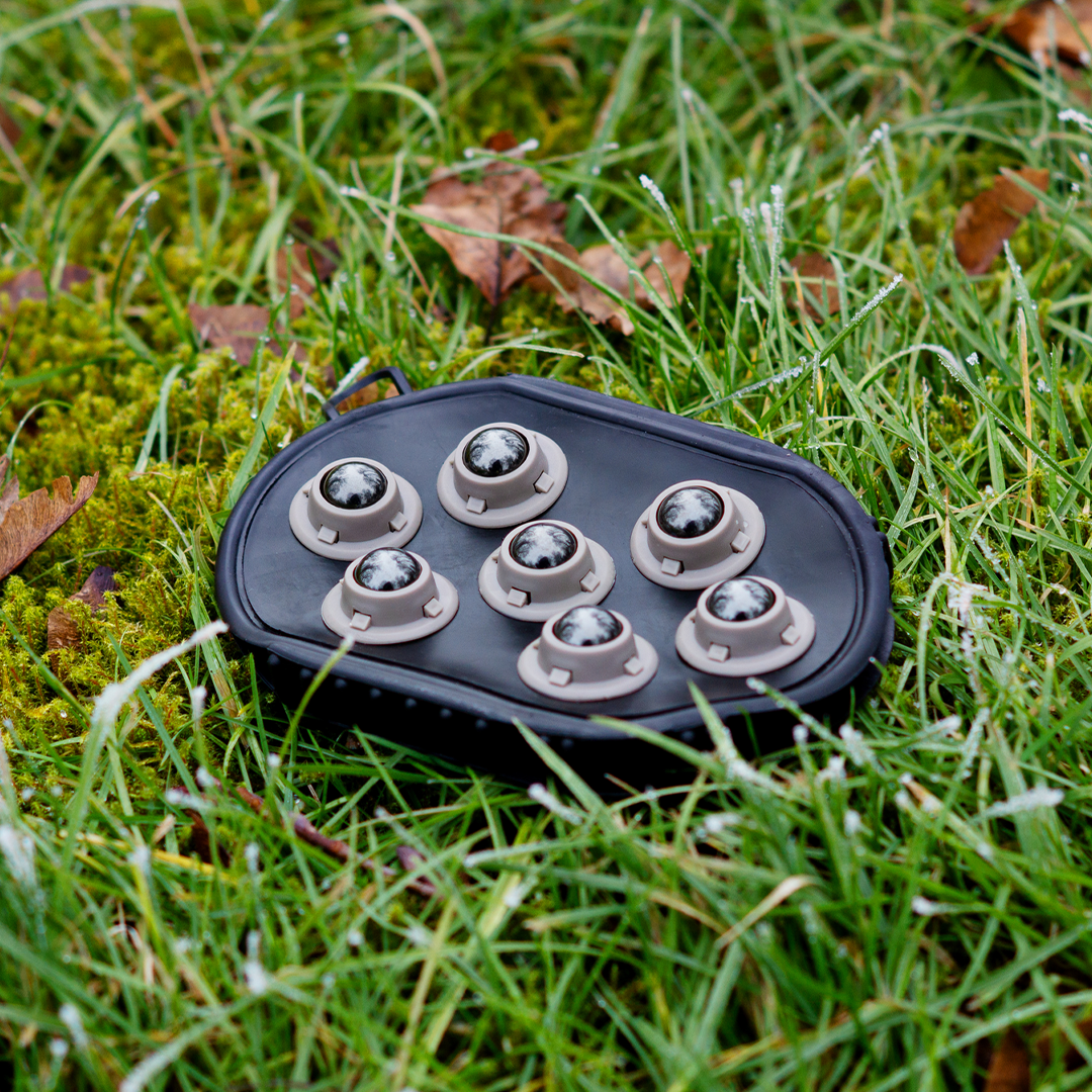 EquiCrown Massagestriegel im Gras liegend